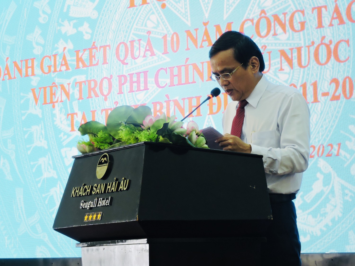 Mr. Nguyen Thai Binh, Director of Binh Dinh Department of Foreign Affairs reporting at the Conference on evaluation of 10-year results of non-governmental aid mobilization in Binh Dinh province (2011-2020)